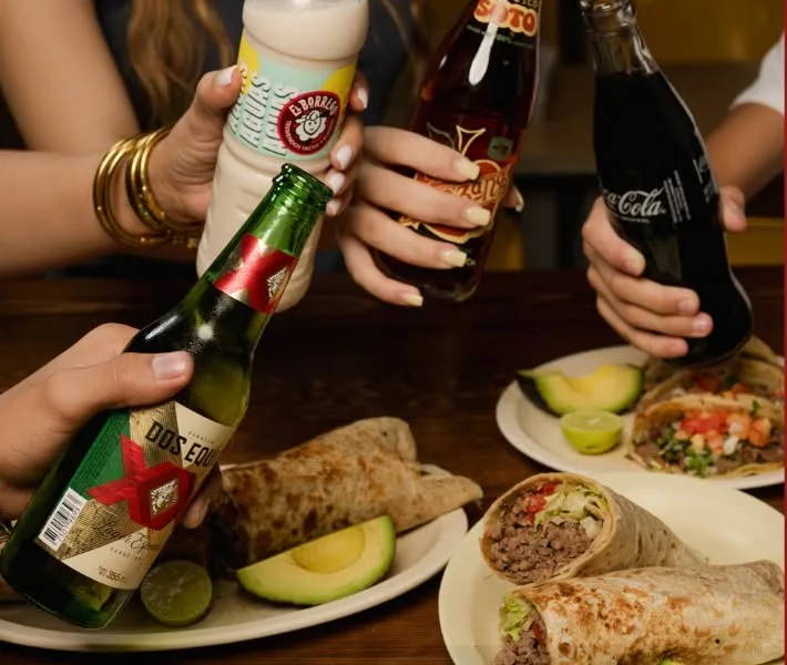 Mesa con burros, tacos y refrescos en El Borrego